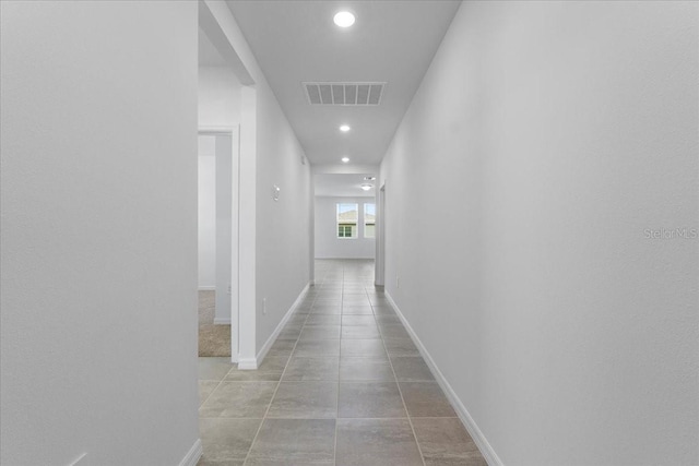 hallway with recessed lighting, tile patterned flooring, visible vents, and baseboards