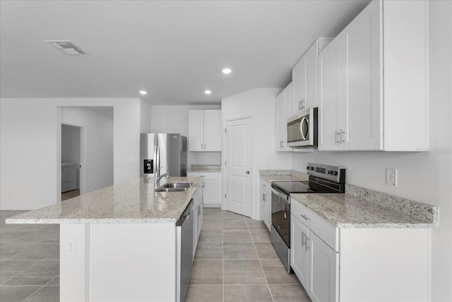 kitchen with visible vents, white cabinets, appliances with stainless steel finishes, a kitchen island with sink, and a sink