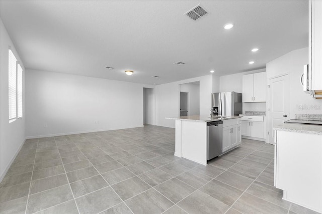 kitchen featuring a center island with sink, visible vents, white cabinets, appliances with stainless steel finishes, and open floor plan