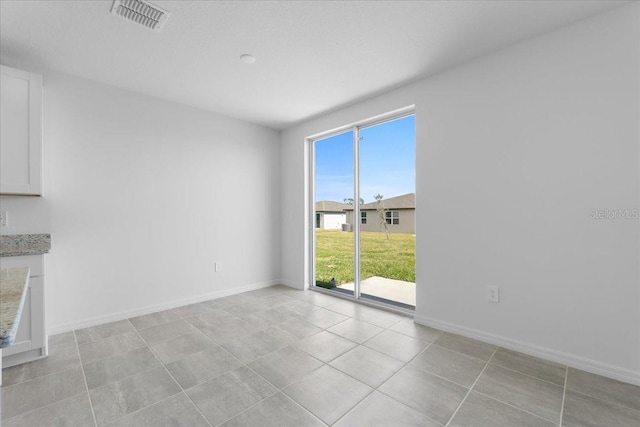 interior space with visible vents, baseboards, and light tile patterned floors