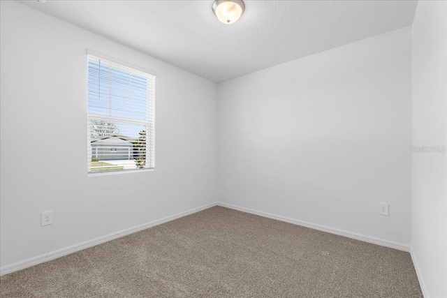 spare room with carpet and baseboards