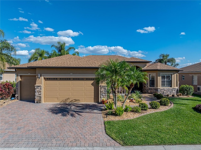 view of front of home featuring stone siding, a front yard, decorative driveway, and stucco siding