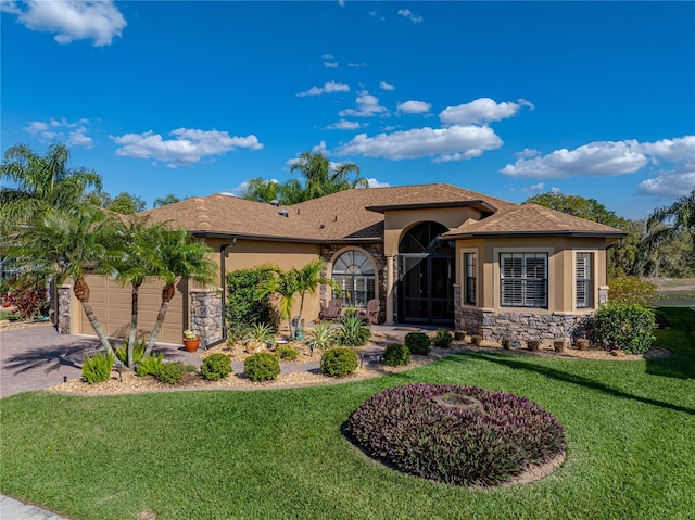 view of front of house with a garage, stone siding, a front lawn, and stucco siding