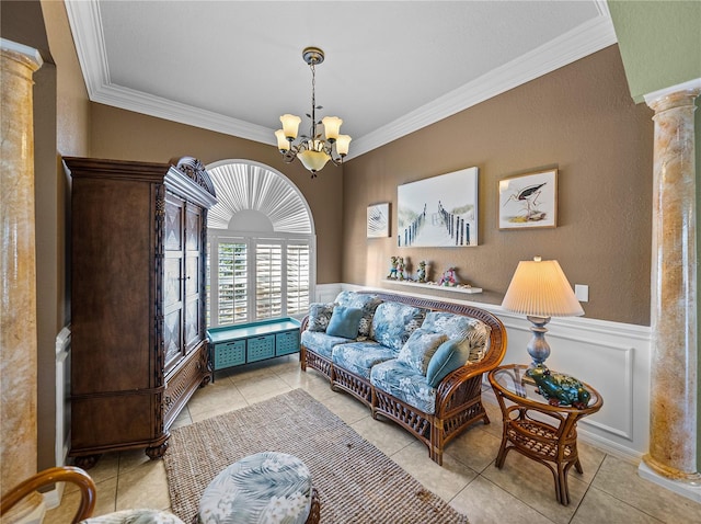 sitting room with light tile patterned floors, decorative columns, wainscoting, ornamental molding, and a chandelier