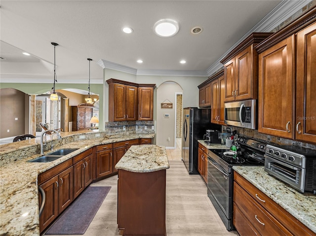 kitchen featuring arched walkways, a toaster, stainless steel appliances, a sink, and light stone countertops