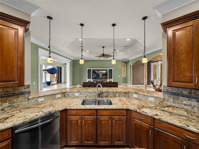 kitchen with a tray ceiling, arched walkways, crown molding, a sink, and dishwasher