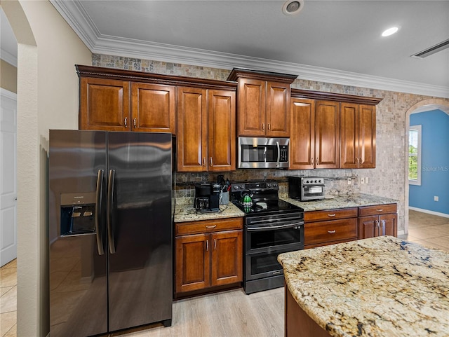 kitchen featuring arched walkways, stainless steel microwave, ornamental molding, double oven range, and refrigerator with ice dispenser