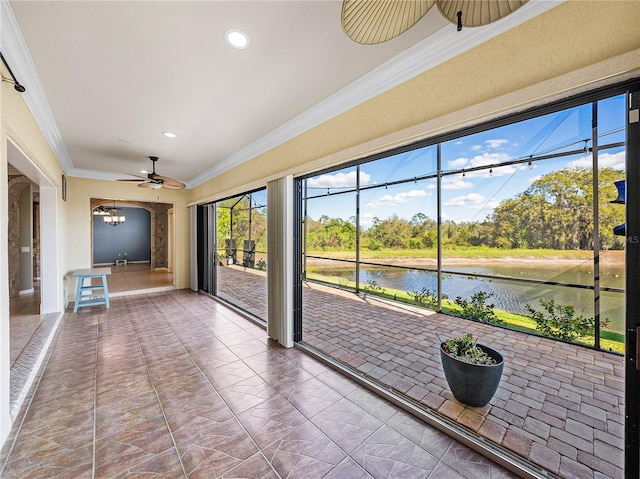 unfurnished sunroom with a water view and ceiling fan with notable chandelier