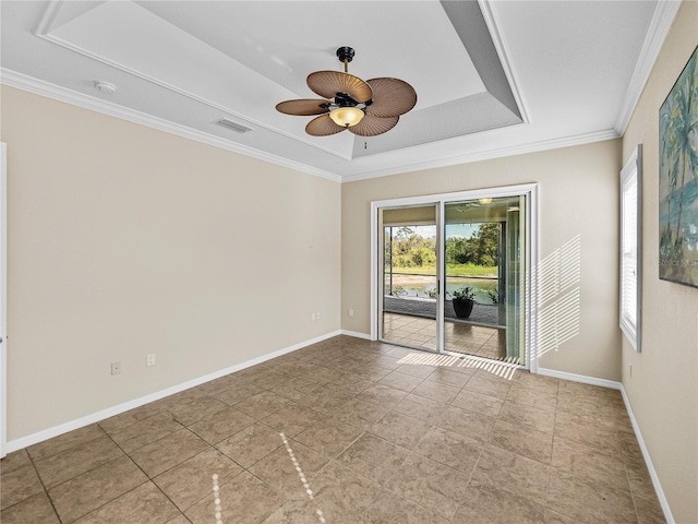 spare room featuring a tray ceiling, visible vents, ornamental molding, a ceiling fan, and baseboards