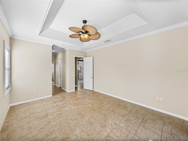 unfurnished room with baseboards, visible vents, ceiling fan, ornamental molding, and a tray ceiling