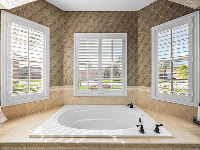 bathroom featuring a garden tub and a healthy amount of sunlight