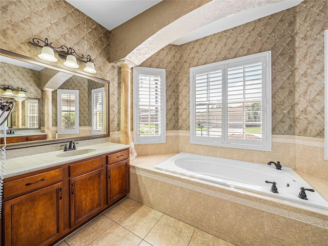 bathroom featuring wallpapered walls, decorative columns, tile patterned floors, a garden tub, and vanity