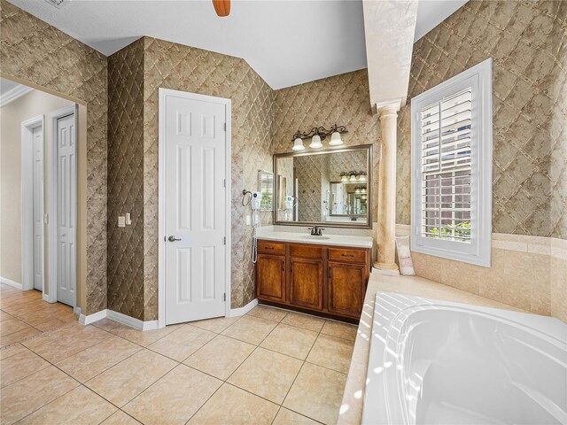 full bath with a garden tub, vanity, baseboards, tile patterned floors, and decorative columns