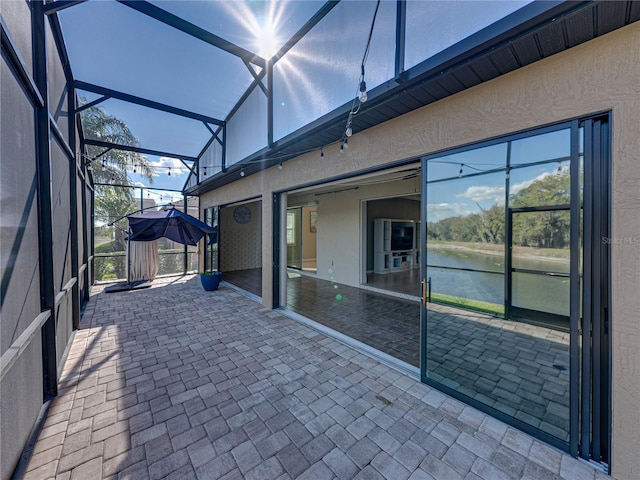 view of patio / terrace with a water view and a lanai