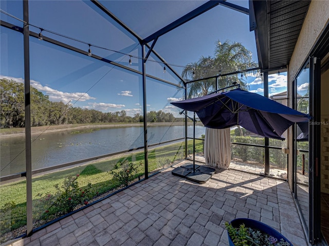 view of patio / terrace with a water view and glass enclosure