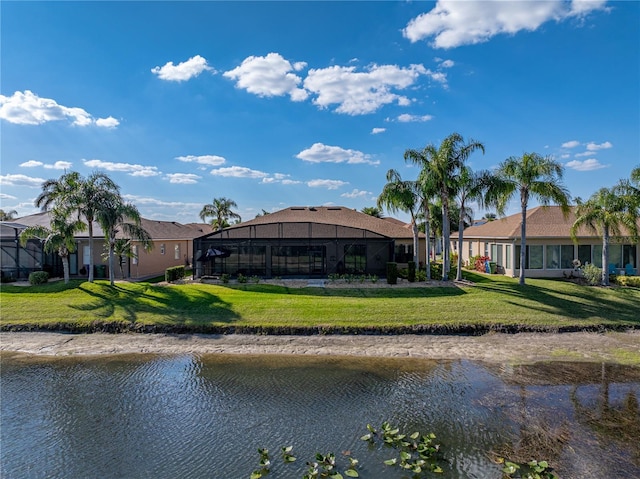 exterior space featuring glass enclosure, a water view, and a lawn