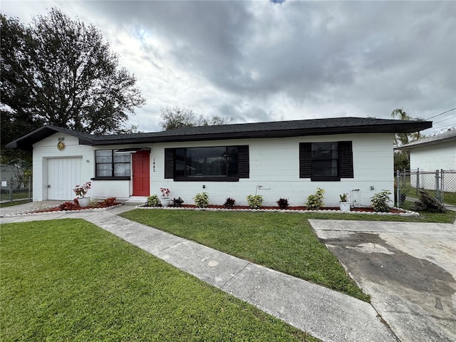 single story home with fence, concrete block siding, and a front yard