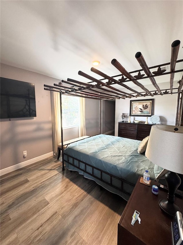 bedroom featuring baseboards and wood finished floors