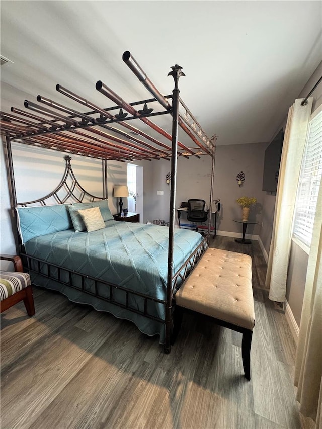 bedroom with baseboards and wood finished floors