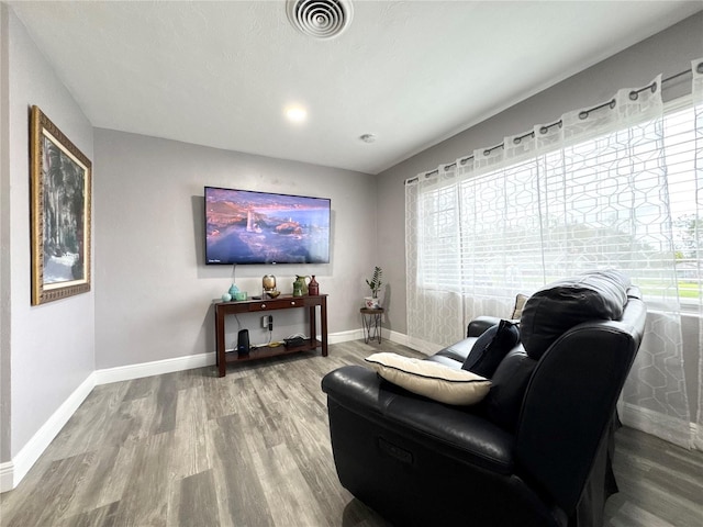 sitting room with visible vents, baseboards, and wood finished floors