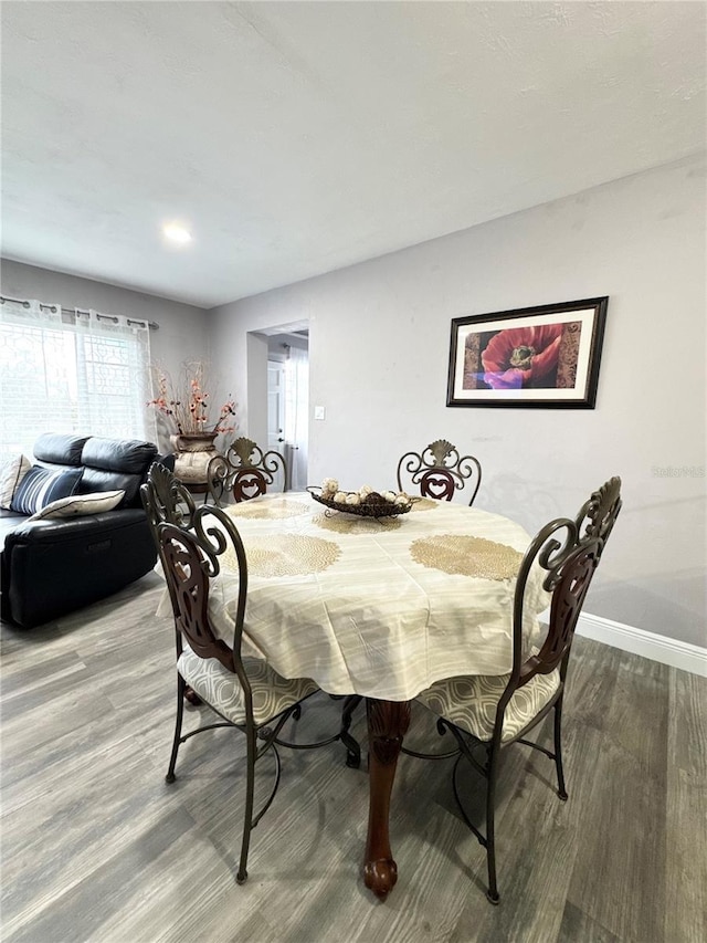 dining space featuring wood finished floors and baseboards