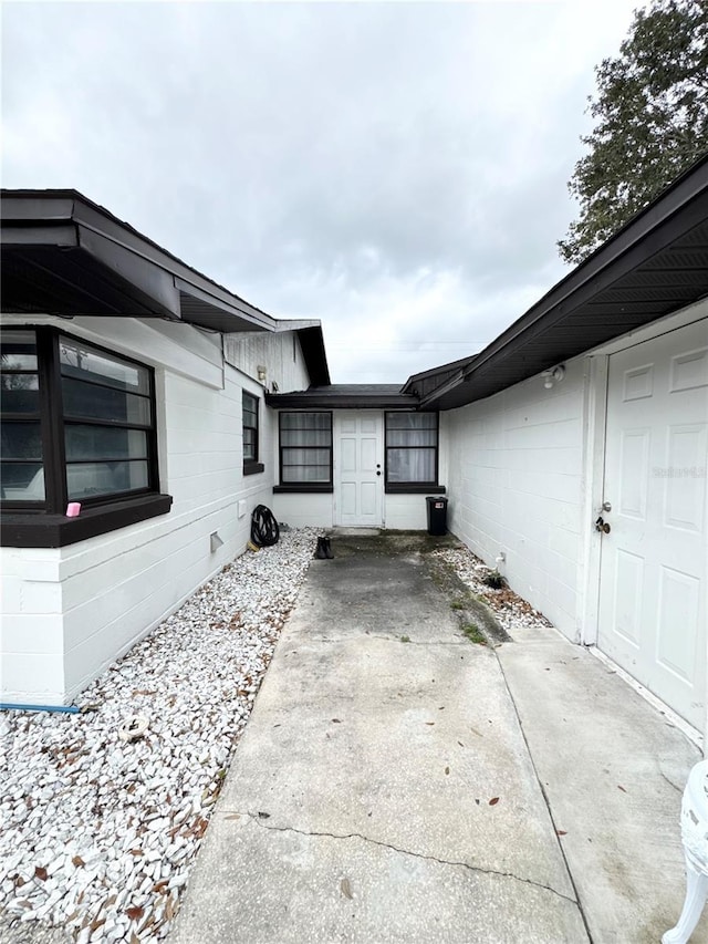 view of home's exterior with a patio area and concrete block siding