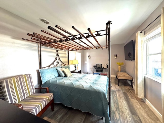 bedroom featuring visible vents, wood finished floors, and baseboards