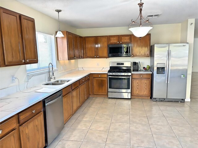 kitchen with visible vents, brown cabinets, appliances with stainless steel finishes, and a sink