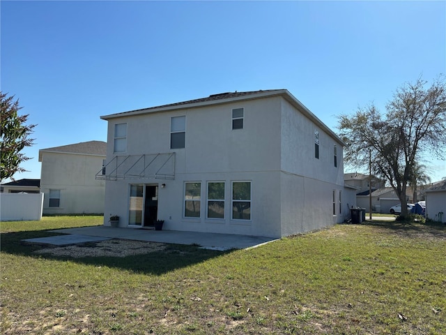 back of property featuring a yard, fence, stucco siding, and a patio area