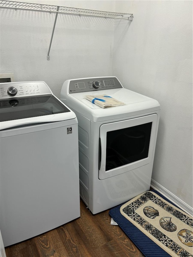 laundry area featuring separate washer and dryer, dark wood-style floors, and laundry area