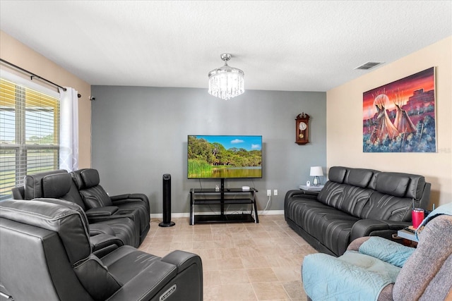 living room featuring visible vents, baseboards, a chandelier, light tile patterned floors, and a textured ceiling