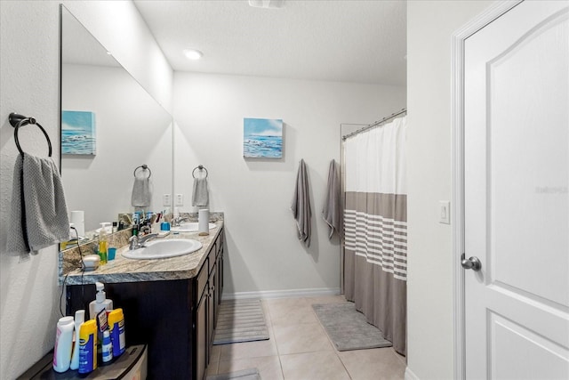 full bathroom featuring tile patterned floors, a textured ceiling, vanity, and baseboards