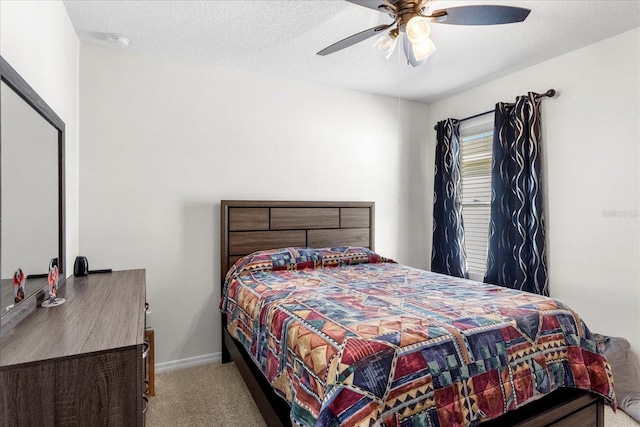 bedroom with ceiling fan, a textured ceiling, baseboards, and carpet