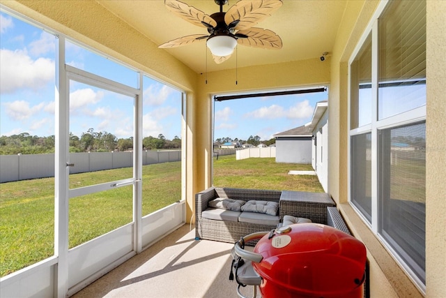 sunroom featuring a healthy amount of sunlight and ceiling fan