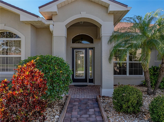 view of exterior entry with stucco siding