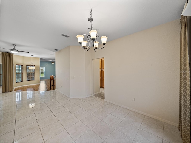 spare room featuring light tile patterned floors, baseboards, visible vents, and ceiling fan with notable chandelier