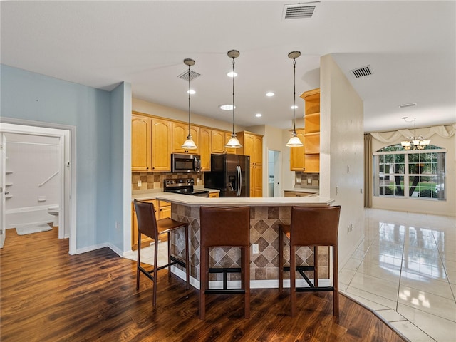 kitchen with tasteful backsplash, visible vents, stainless steel appliances, and dark wood-type flooring