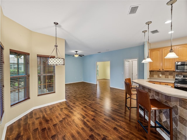 kitchen with appliances with stainless steel finishes, light countertops, visible vents, and decorative backsplash