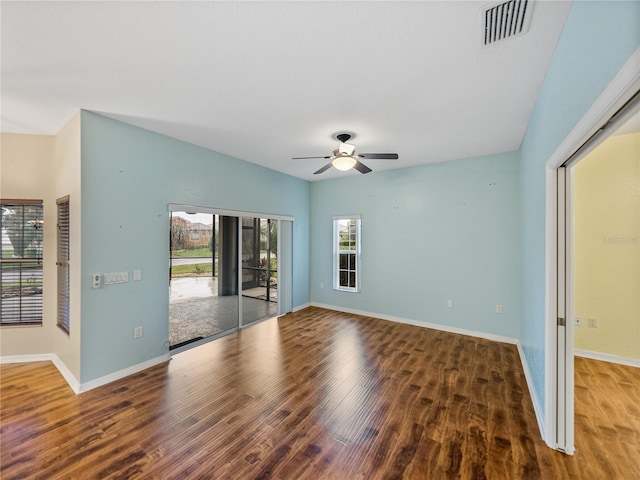 empty room featuring baseboards, visible vents, and wood finished floors