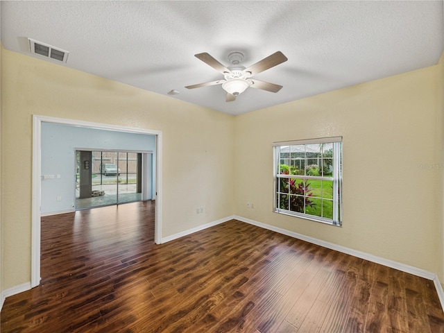 spare room featuring plenty of natural light, wood finished floors, and visible vents