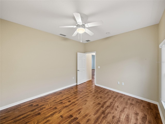 empty room with a ceiling fan, baseboards, visible vents, and wood finished floors