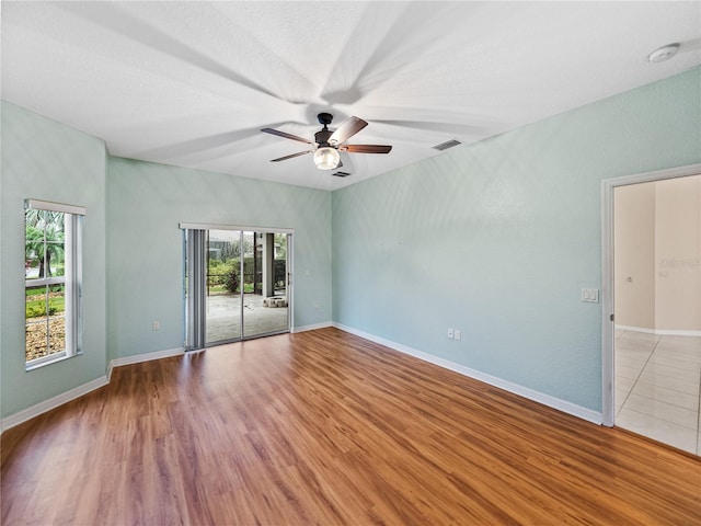 unfurnished room with light wood-style floors, a healthy amount of sunlight, and visible vents