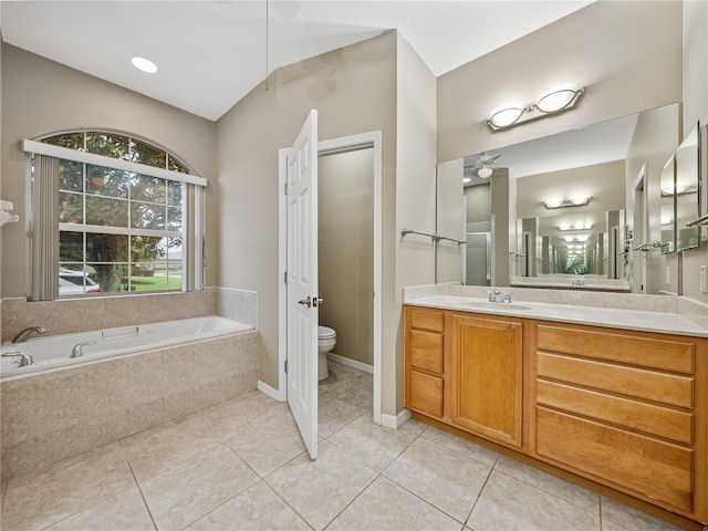 full bathroom featuring a bath, vanity, tile patterned flooring, and toilet