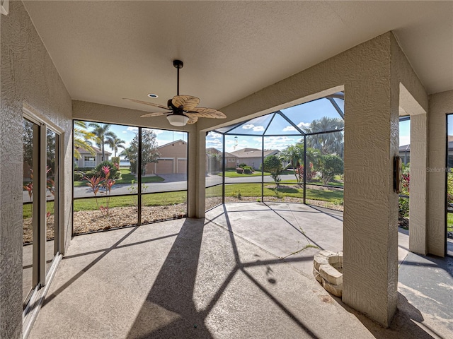 unfurnished sunroom with a residential view and a healthy amount of sunlight