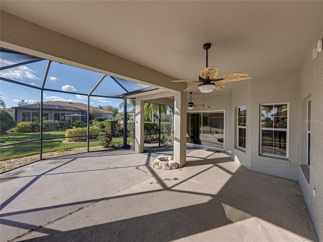 view of patio with a ceiling fan and glass enclosure