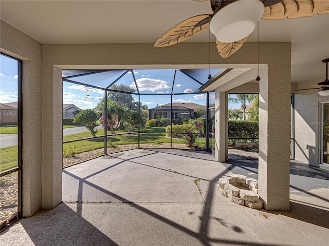 unfurnished sunroom with ceiling fan