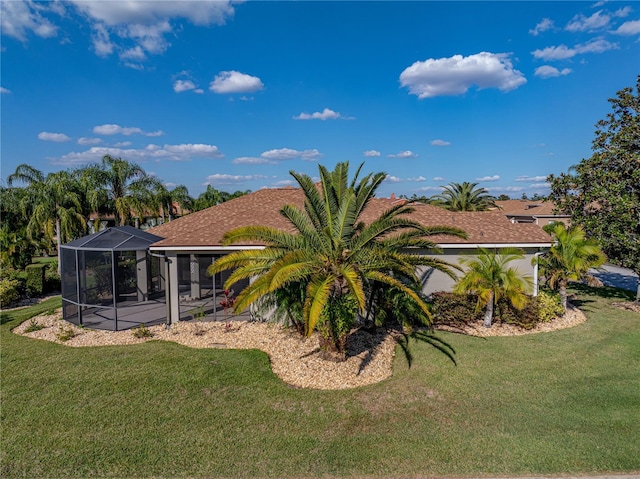 rear view of property featuring a patio, a lawn, and a lanai