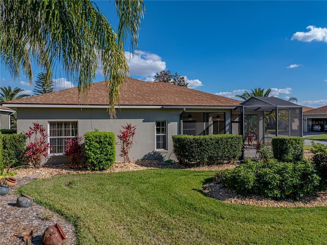 view of front of home featuring a lanai, a front yard, and stucco siding