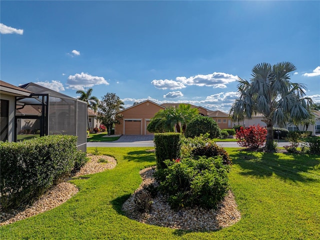 view of yard featuring a garage and a lanai