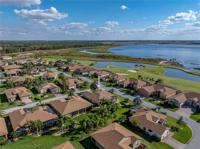 drone / aerial view featuring a residential view, a water view, and golf course view